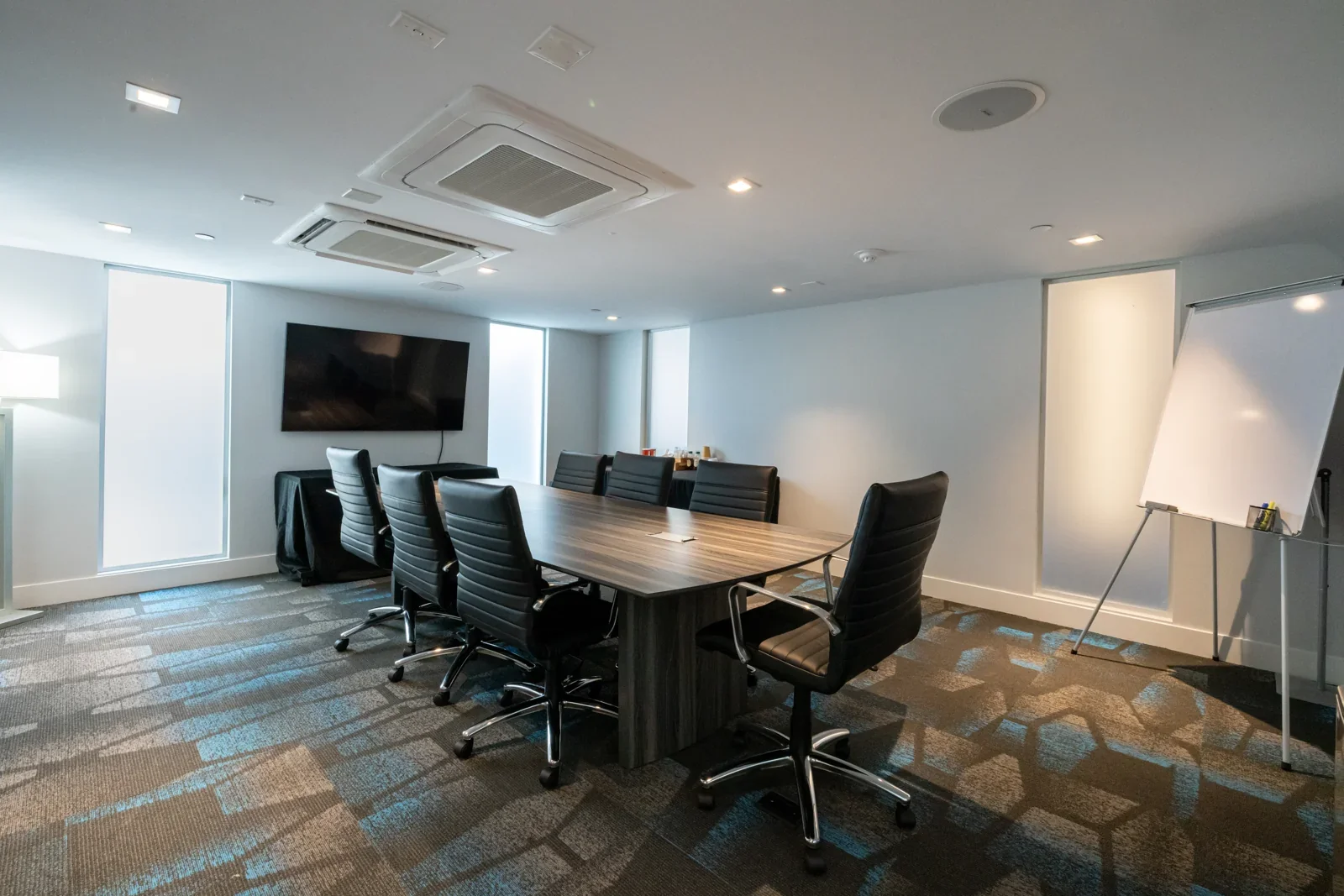 Private boardroom with a meeting table, chairs, television, and whiteboard at H2O Hermosa Beach Hotel