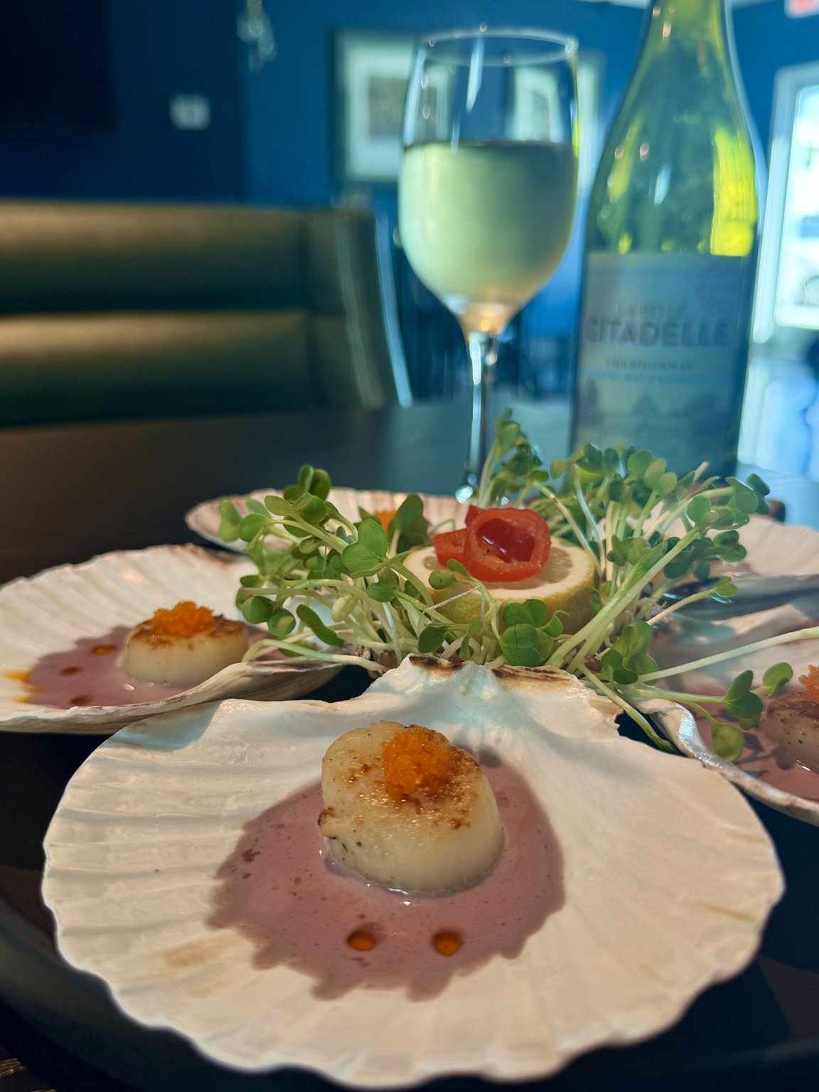 Scallops served in shells beside French white wine at Covinten in Hermosa Beach