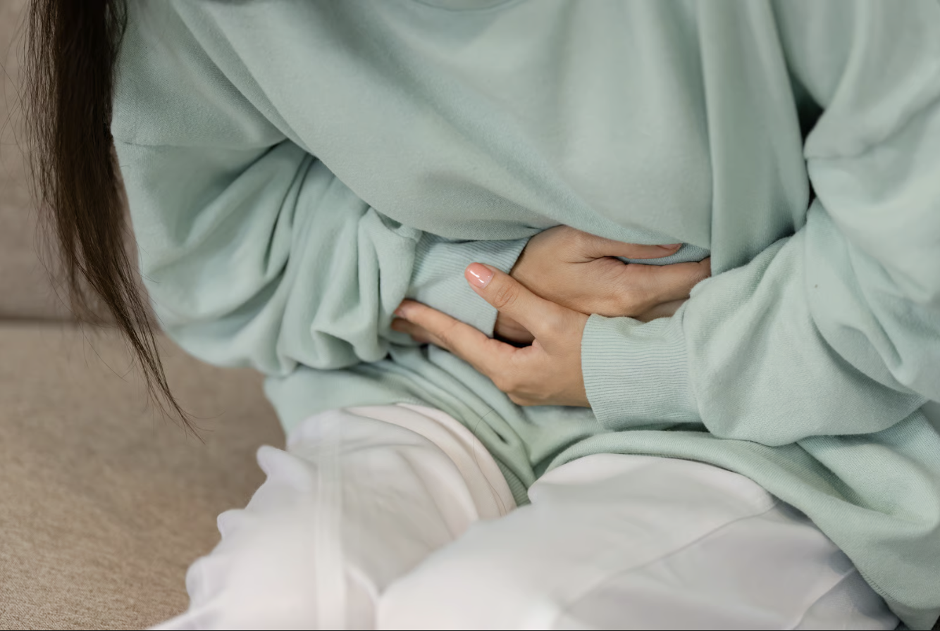 Someone holding their belly from nausea.