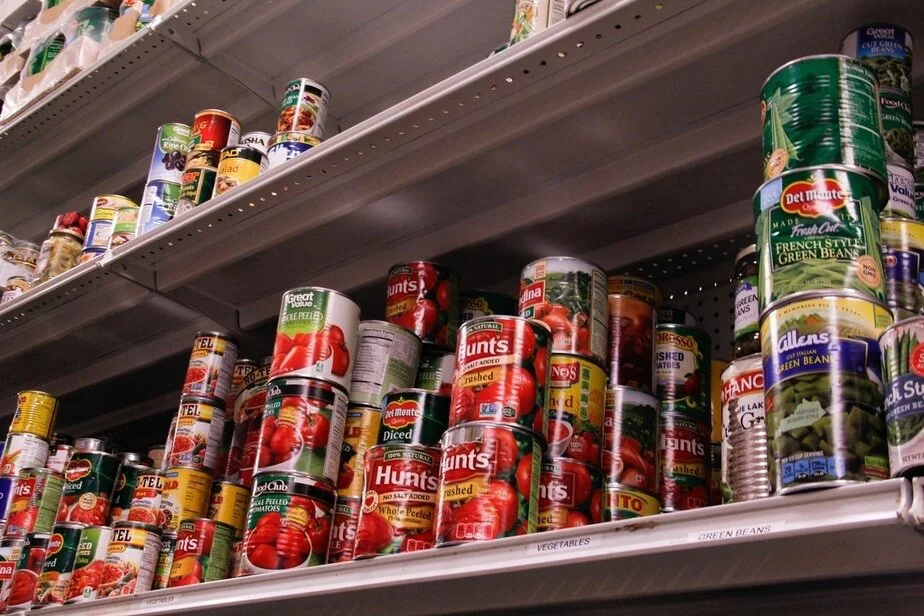 Shelves of canned vegetables and beans in a grocery store.