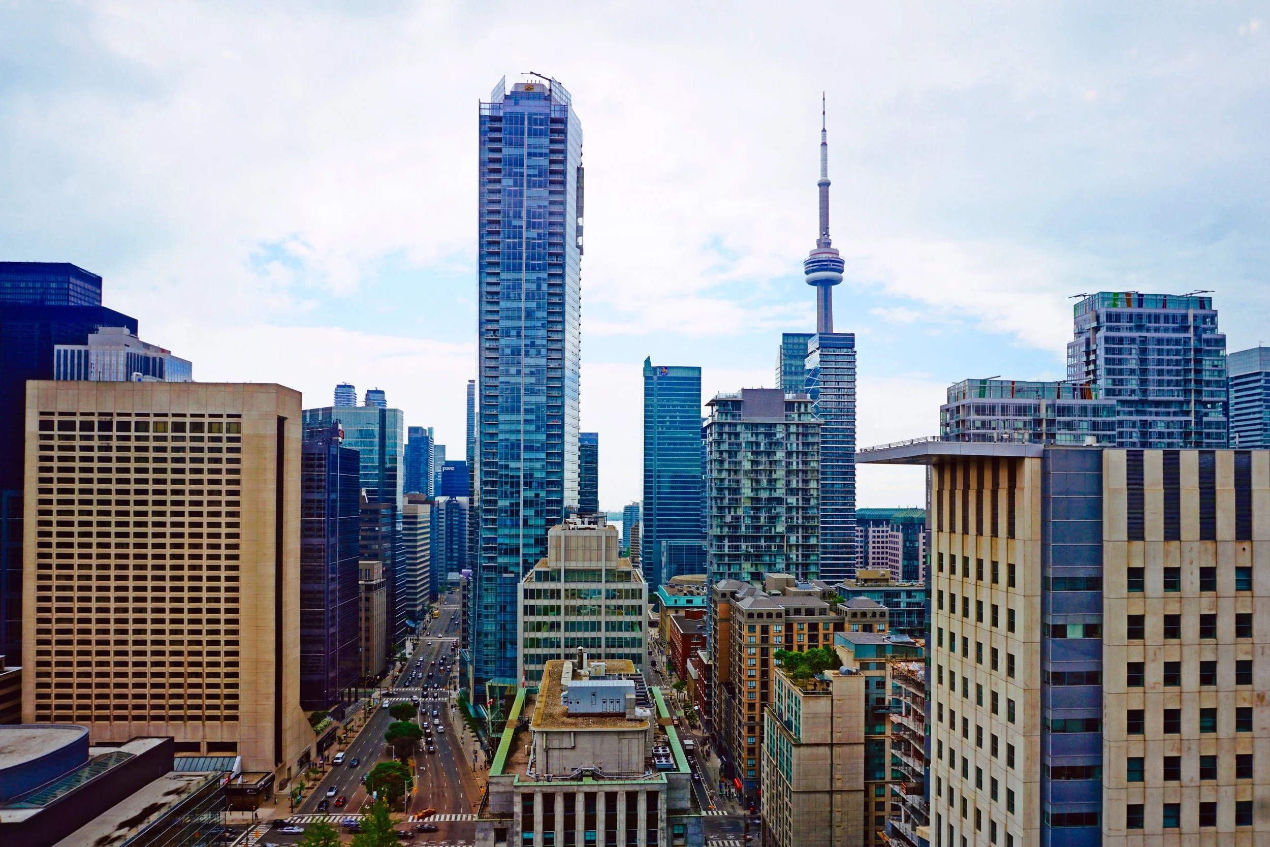 Skyline view of downtown Toronto featuring the CN Tower surrounded by modern skyscrapers and buildings.