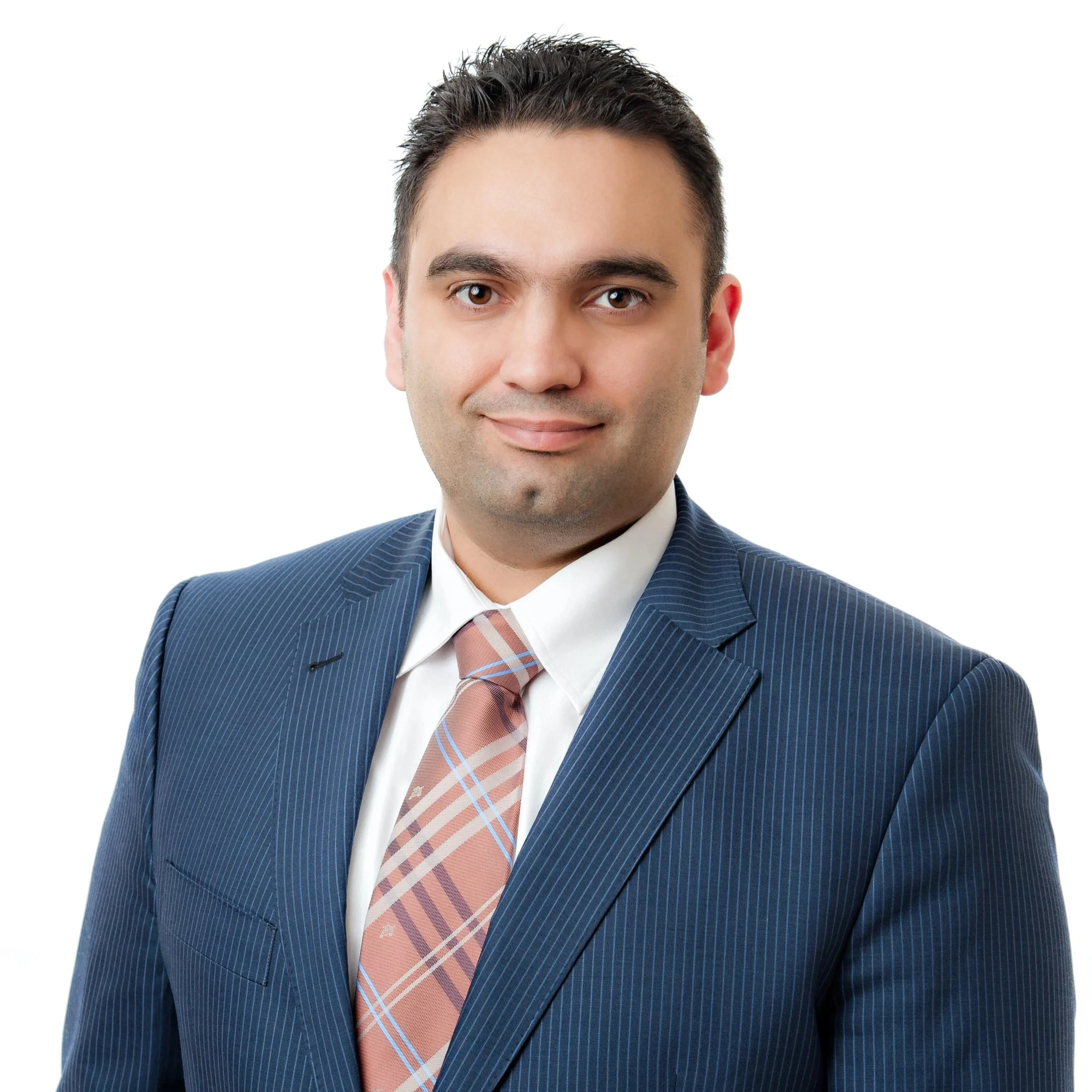 Arash Fatemi, commercial real estate broker. A professional portrait of a middle-aged man in a blue pinstripe suit, white shirt, and a pink plaid tie, smiling slightly against a white background.
