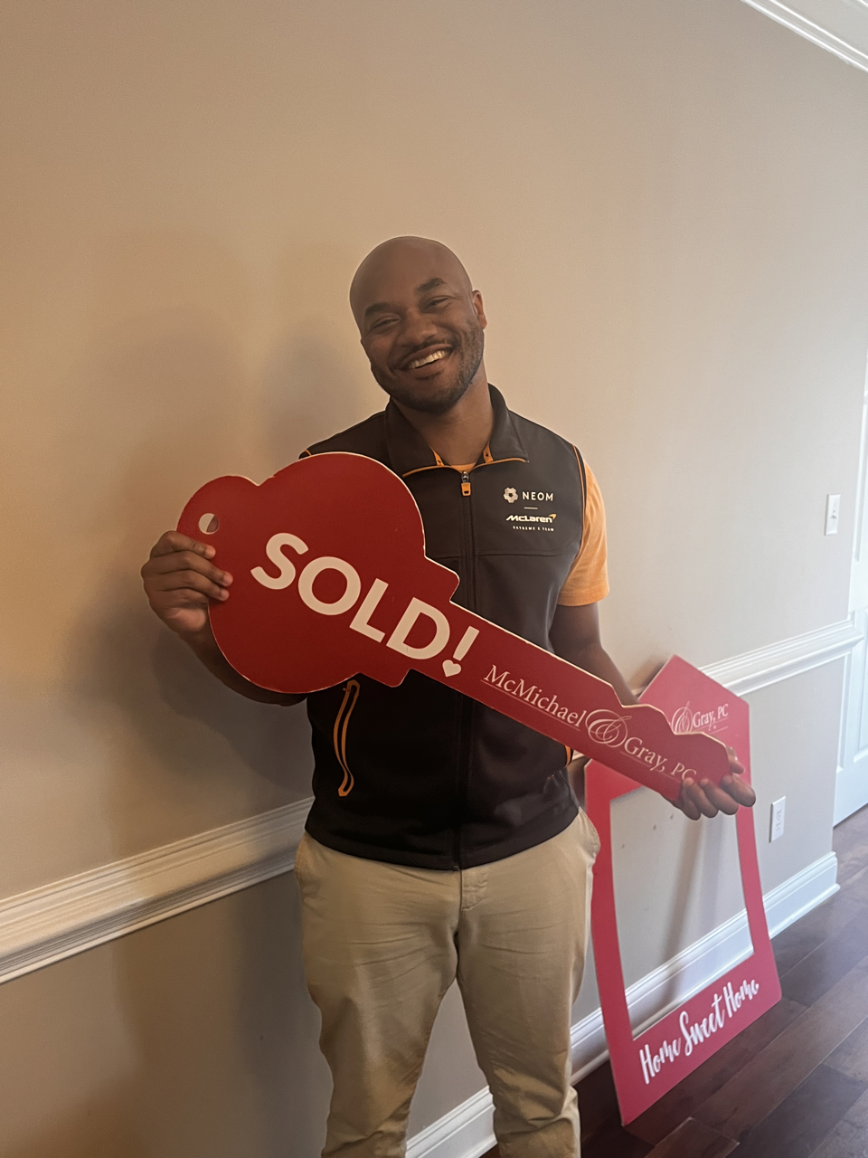 A first time homebuyer stands with a prop after closing on his new townhome. The home was sold by Cortney Patterson the owner and lead realtor of Vyntra Realty Group.
