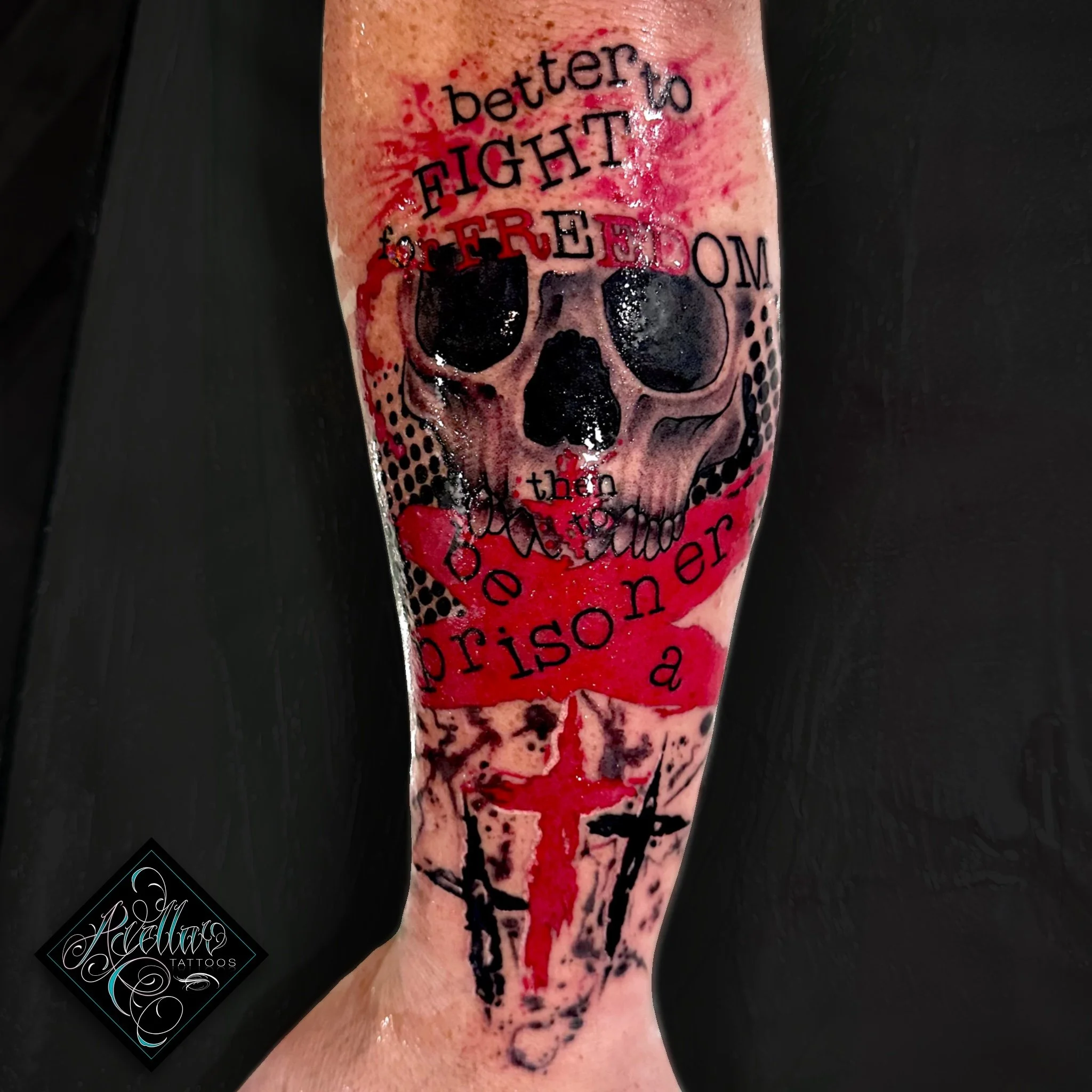 Tattoo of a skull with black eye sockets, overlaid with red and black text that says 'Better to fight and be a prisoner than...'