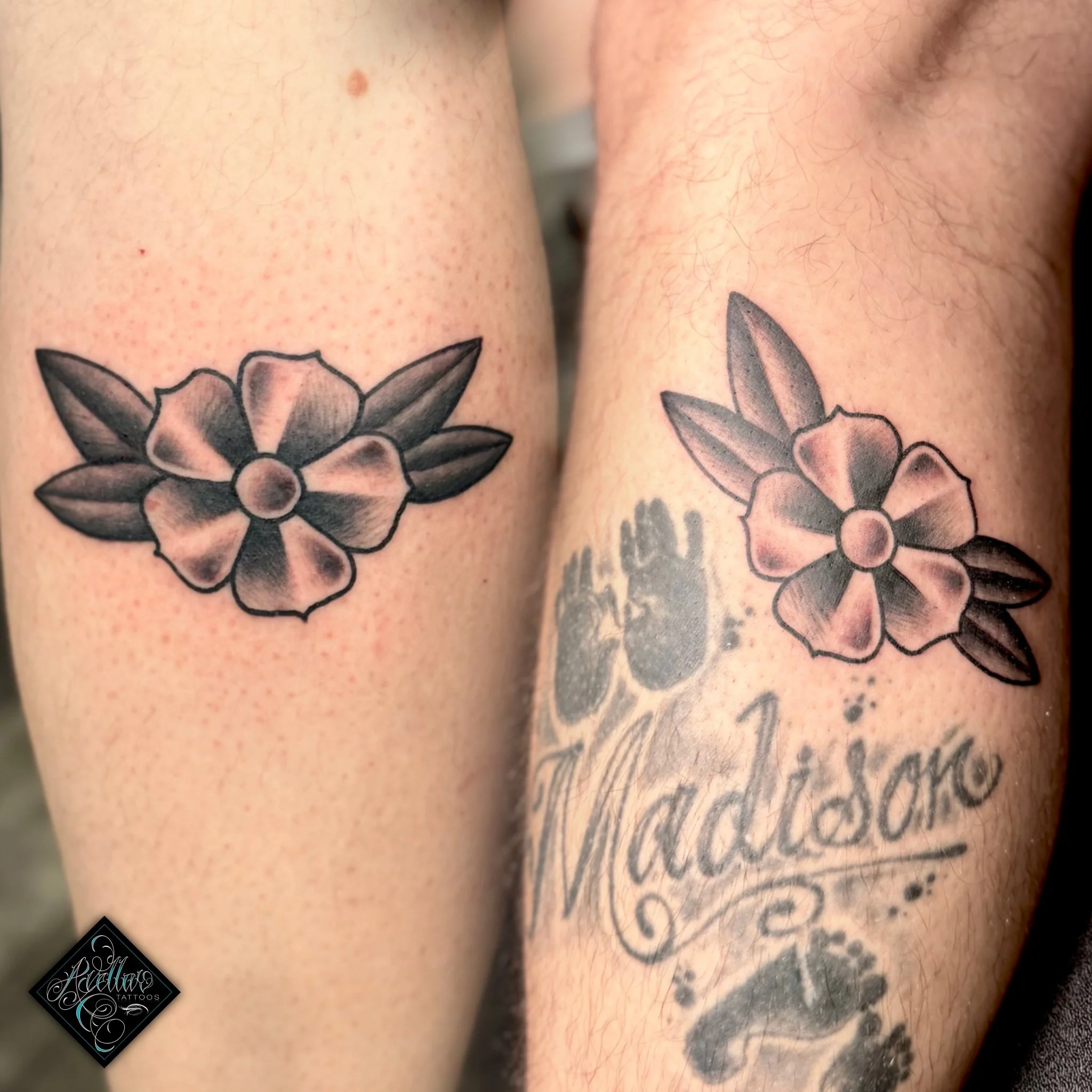 Two matching black and gray floral tattoos on forearms, one with the word 'Madison' and a paw print underneath.