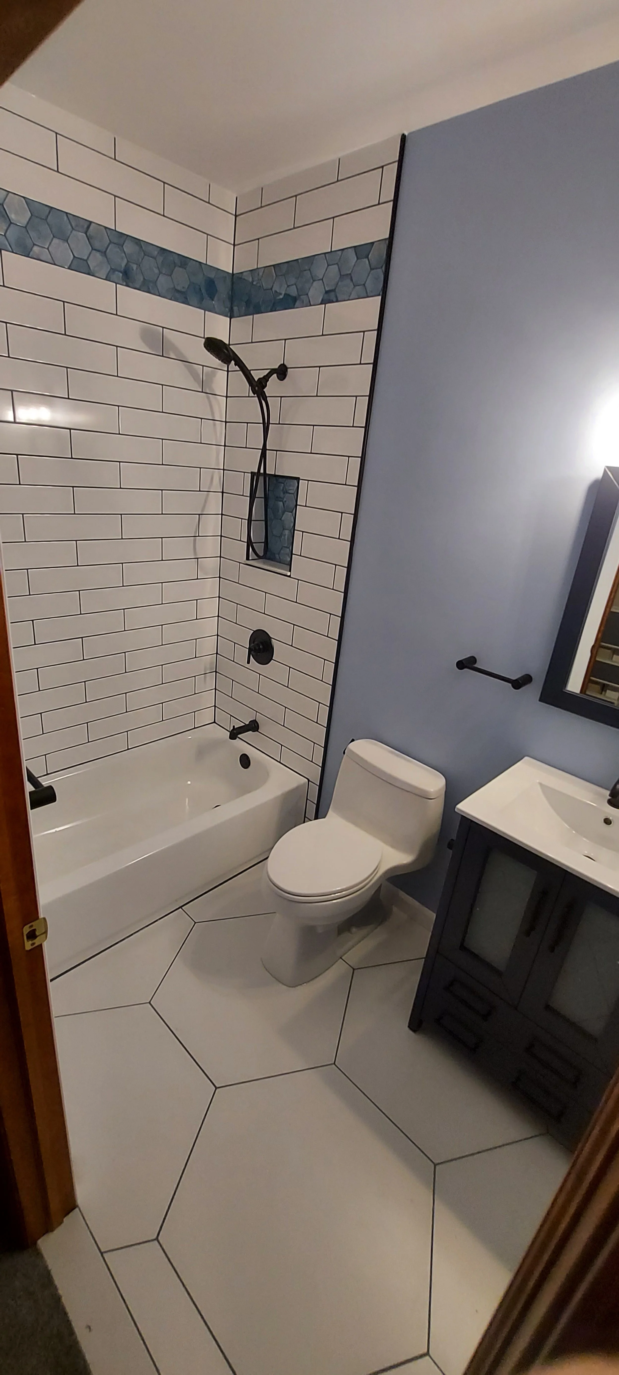 Shot of the bathroom before the doors to show the tile work.