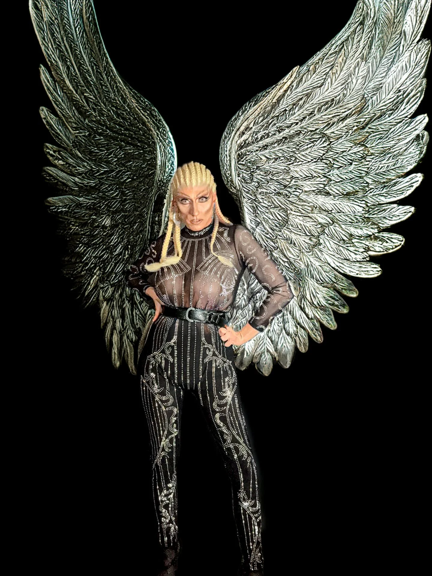 Drag-Künstlerin Liz Queera als dunkler Engel, mit riesigen silbernen Flügeln und einem glitzernden schwarzen Body.