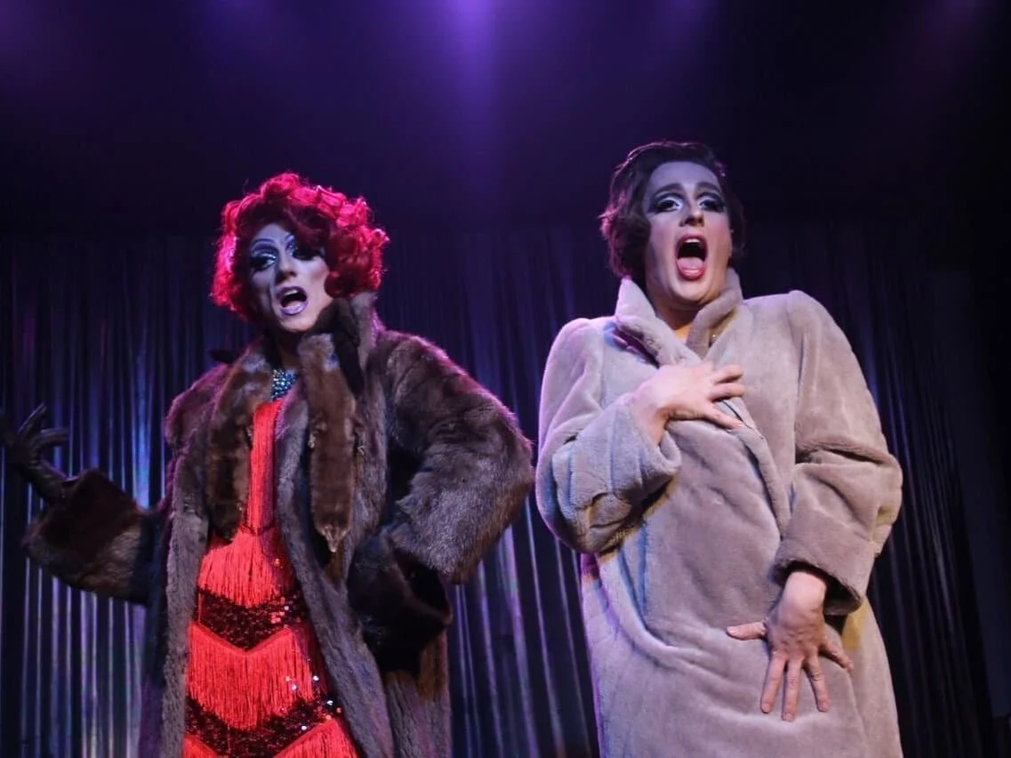 Drag-Künstlerin Liz Queera (links) mit roten Haaren und Pelzmantel singt zusammen mit Gloria Gossip (rechts) performt "Nowadays" aus dem Film "Chicago"