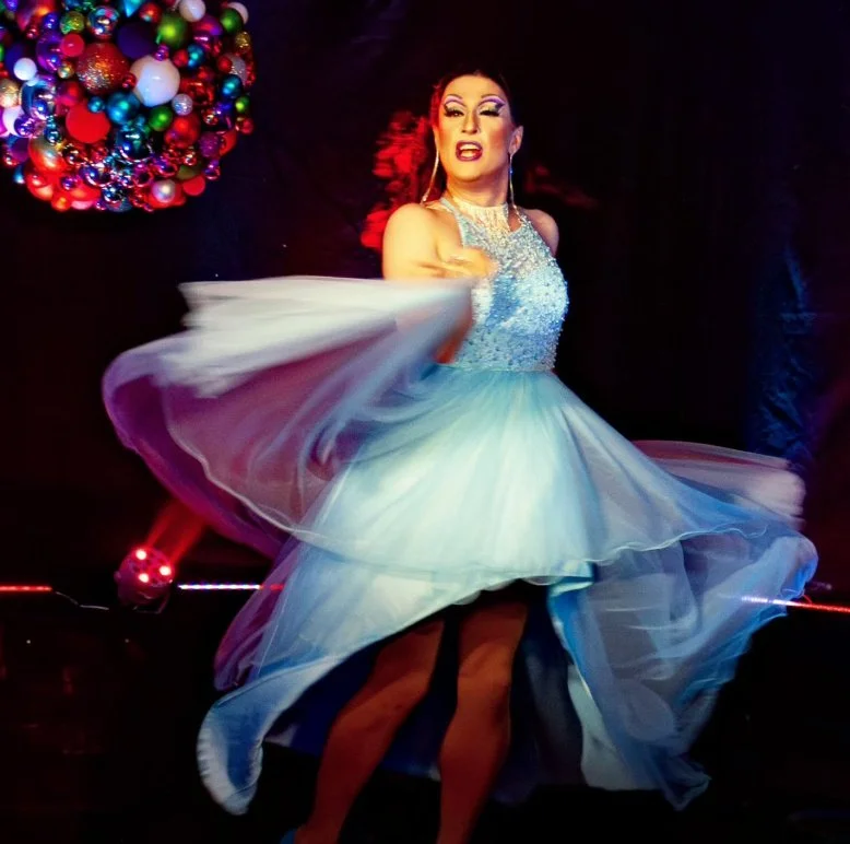 Gloria Gossip tanzt mit einem blauen Kleid