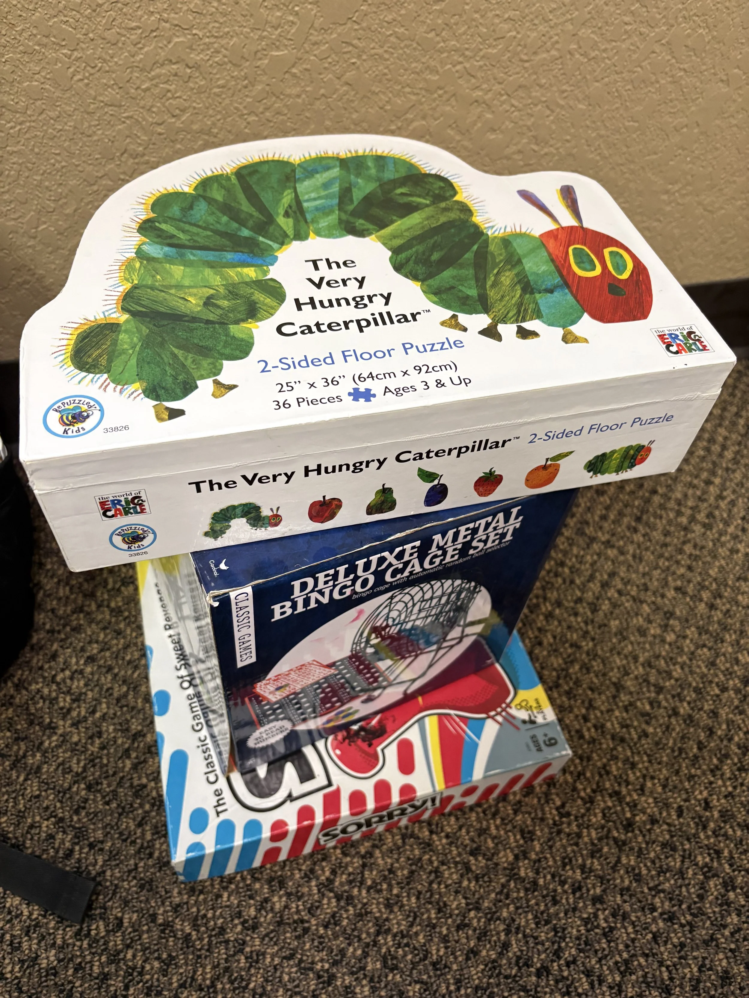 Box of the Very Hungry Caterpillar 2-sided floor puzzle with an illustrated caterpillar on the top and images of fruits on the side.