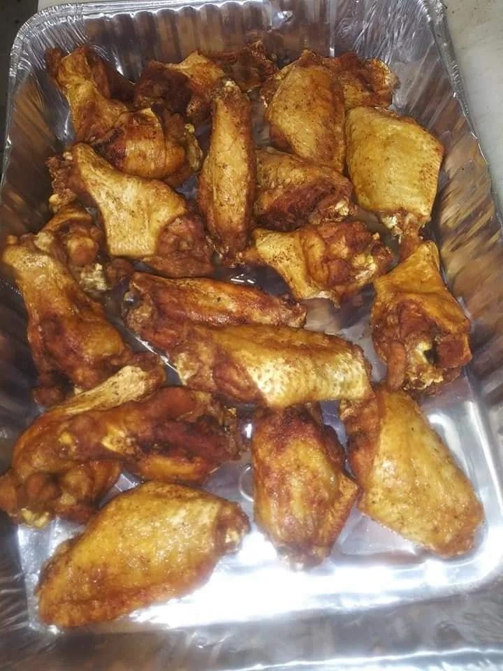 Tray of cooked chicken wings and drumsticks.