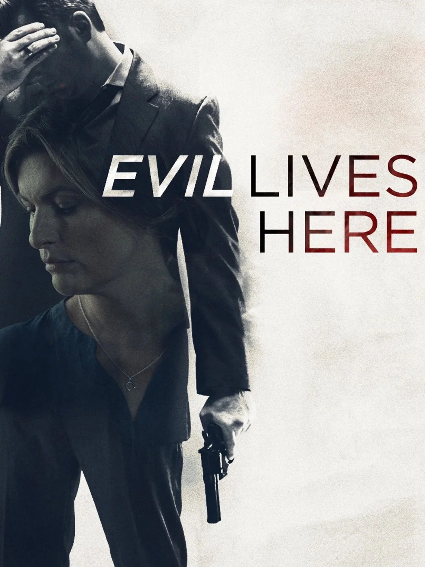 A person wearing a suit holding a handgun, with the text 'Evil Lives Here' overlaid on the right side of the image.