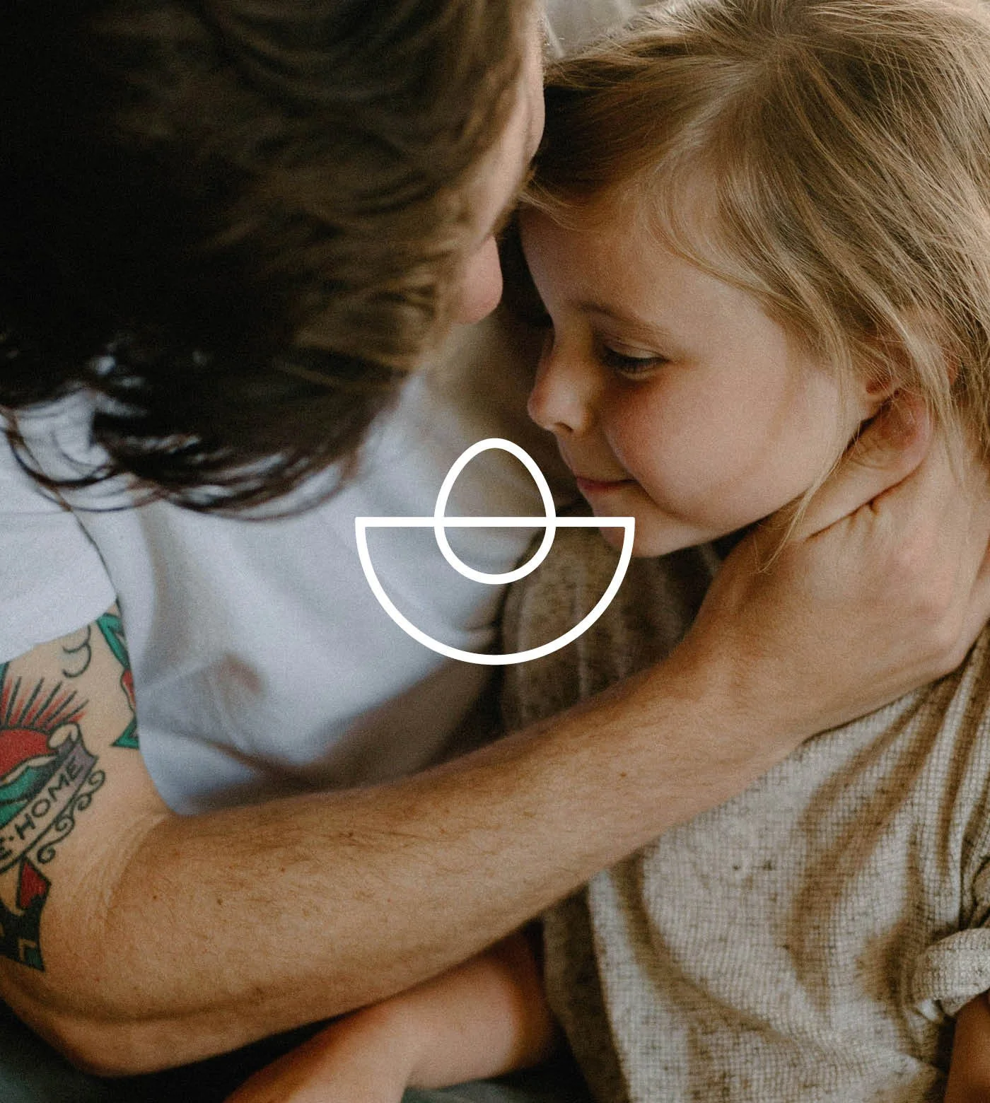 A father holding a young girl in an embrace.