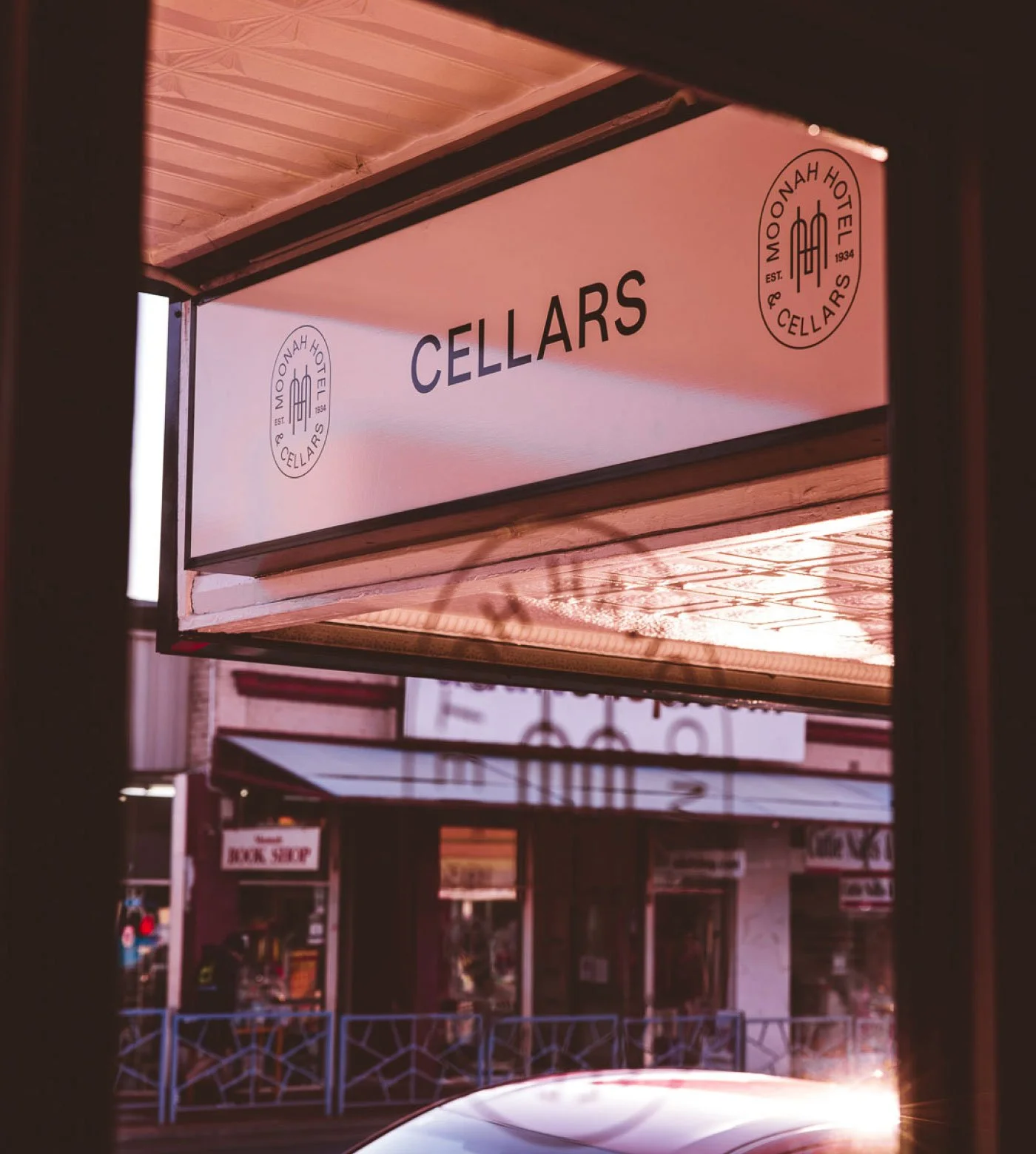 Storefront window with a sign reading "CELLARS" and a logo for Moonah Hotel & Cellars.