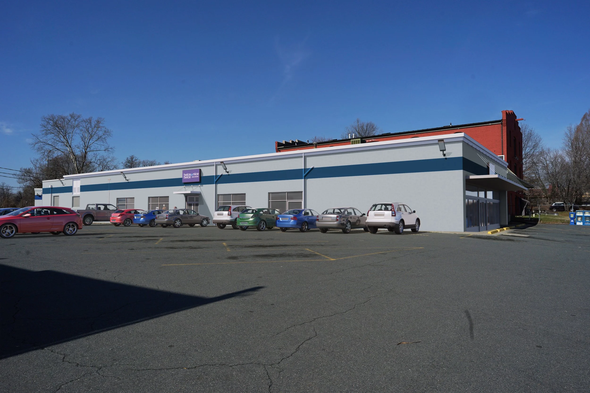 A commercial building with a large parking lot filled with cars, and a purple sign reading 'twice nice' on the front of the building. Clear blue sky and leafless trees in the background.