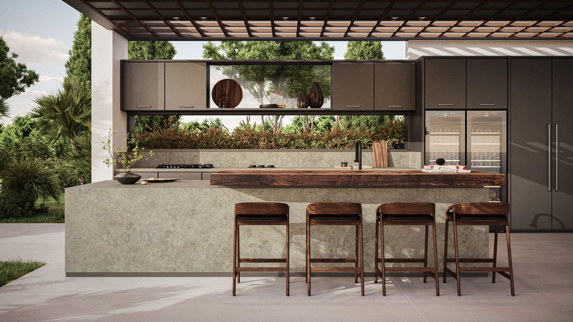 Modern outdoor kitchen with a concrete island, four wooden bar stools, dark cabinets, a built-in wine fridge, and a lush green landscape in the background.