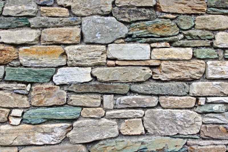 Close-up of a stone wall with variously shaped and colored stones.