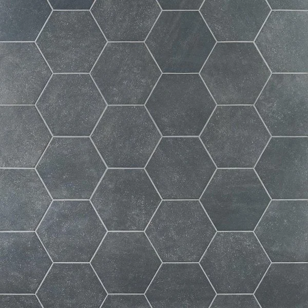 Close-up of a dark gray tiled floor with hexagon-shaped tiles and light-colored grout lines.