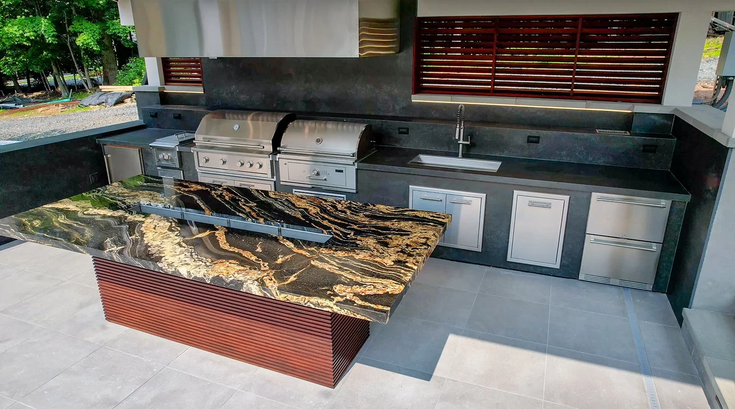 High-end outdoor kitchen with dual stainless steel grills, sleek cabinetry, and a striking granite island bar. The bold countertop adds luxury style to this fully functional backyard cooking and dining space.
outdoor kitchen with granite countertop, 