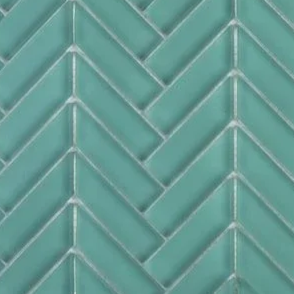 Close-up of teal-colored glass tiles arranged in a herringbone pattern.