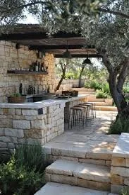 Outdoor stone bar with seating area, patio, and lush greenery supporting a relaxed outdoor setting.