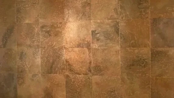 Close-up of a tiled floor with brown, textured tiles arranged in a grid pattern.