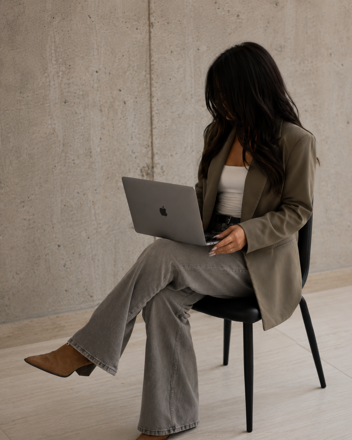 a woman working on a computer with black hair sitting in a chair