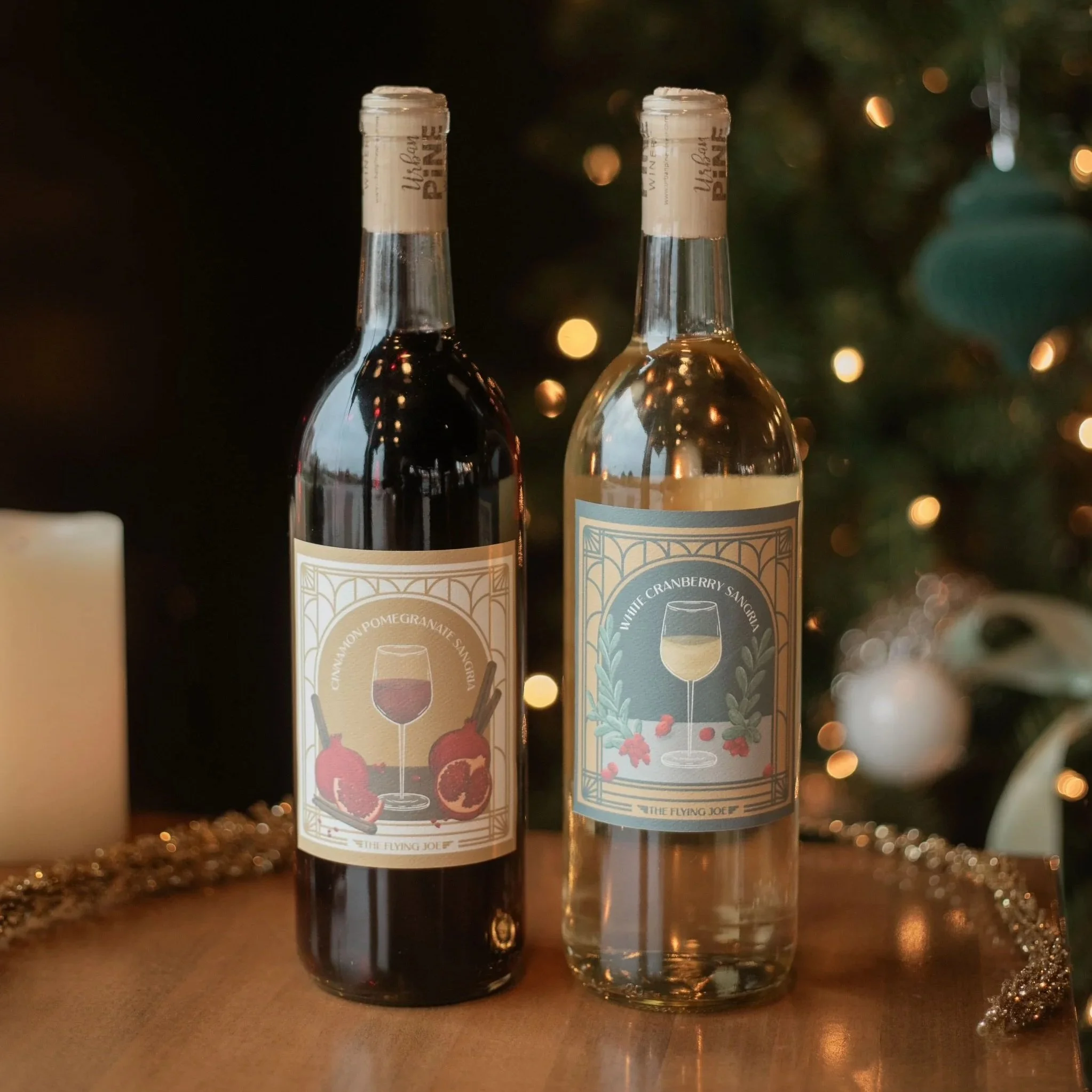 Photo of two wine bottles, a red and white, with custom illustrated labels in an art deco style .