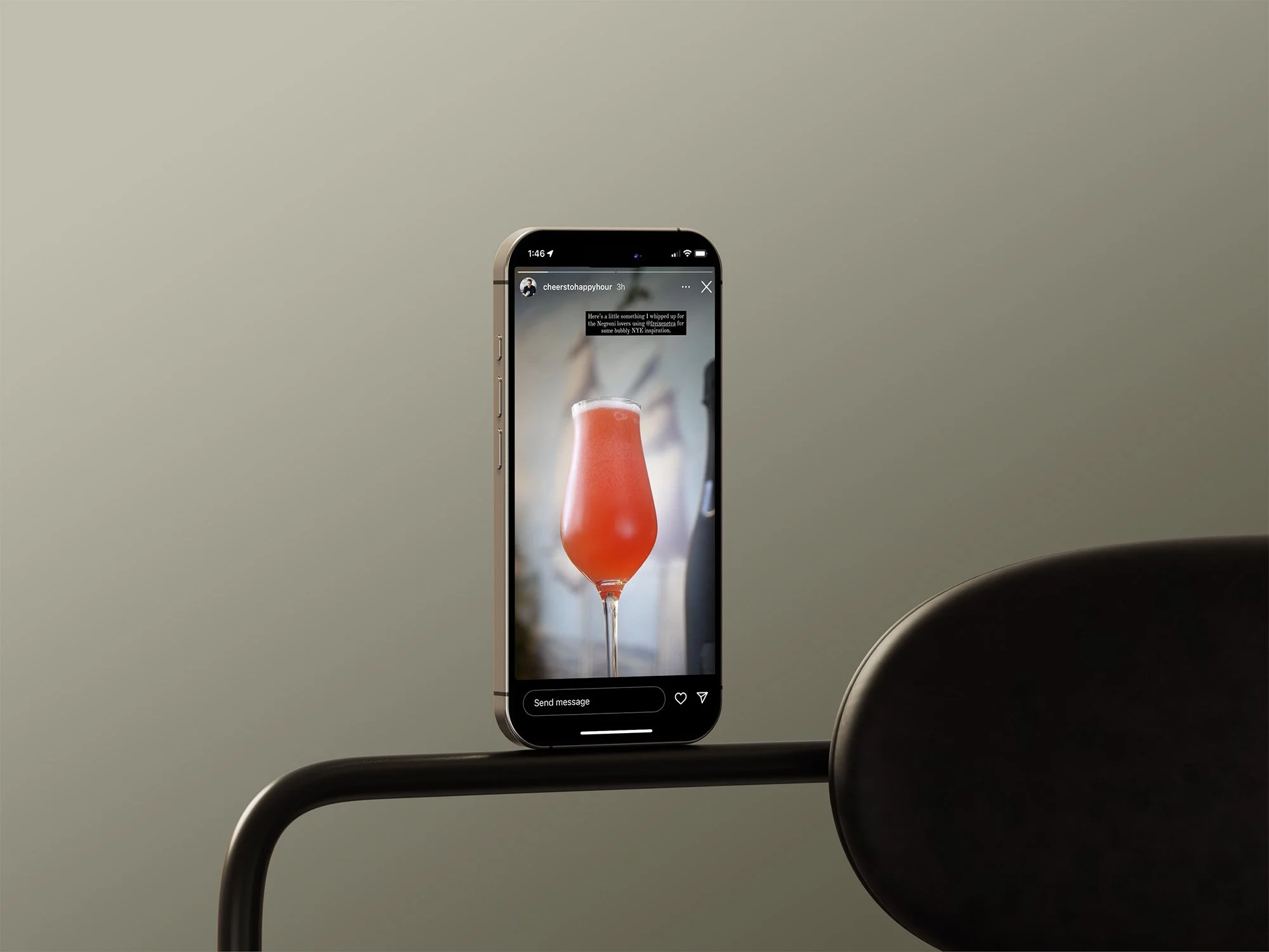 A smartphone displaying a photo of a pink cocktail in a tall, curvy glass.