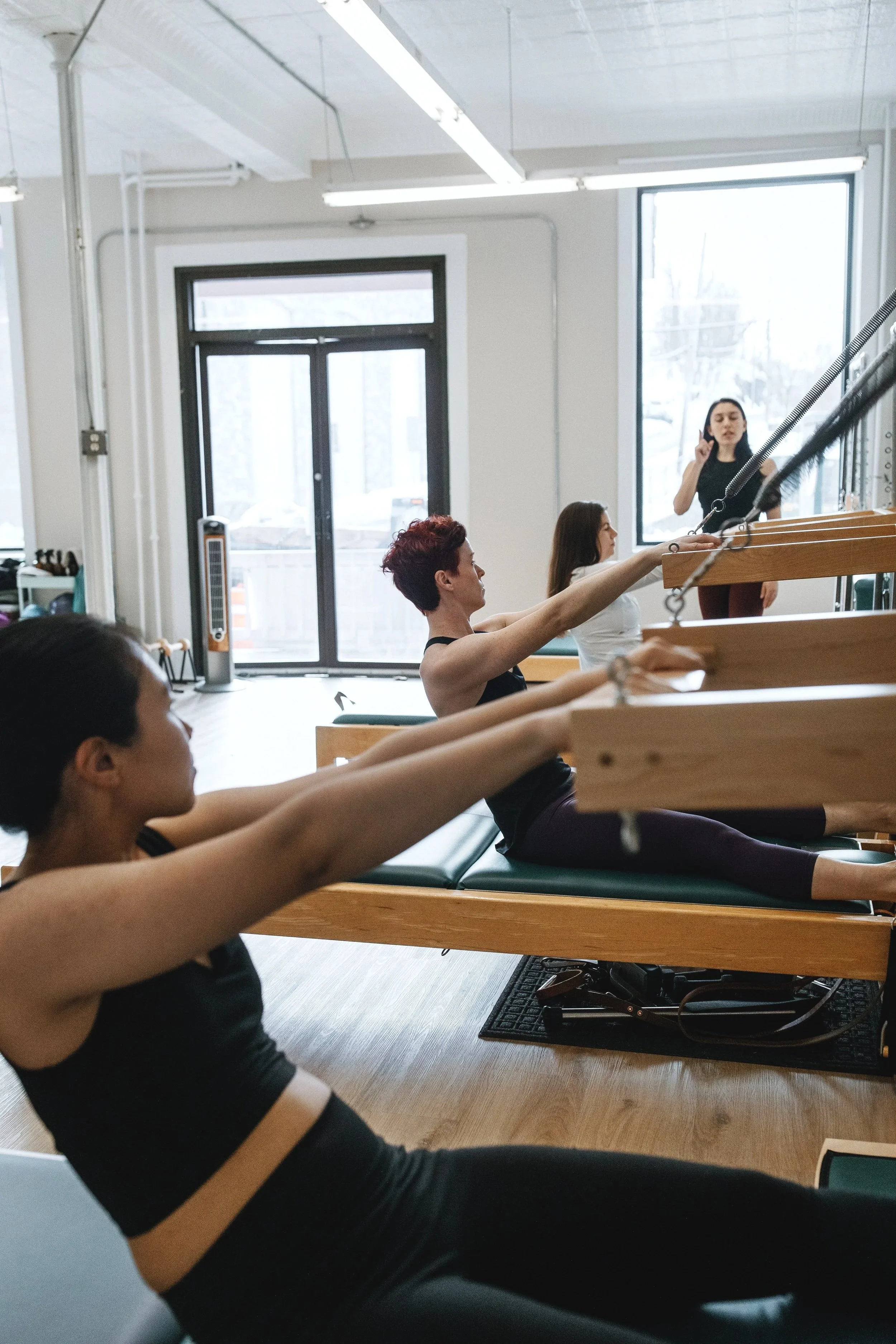 Pilates Instructor teaching students in a group class
