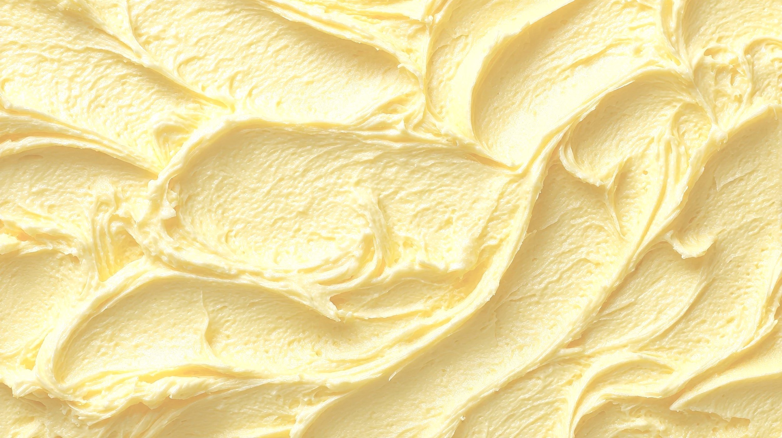 Close-up of creamy butter spread with a smooth texture and soft yellow color.