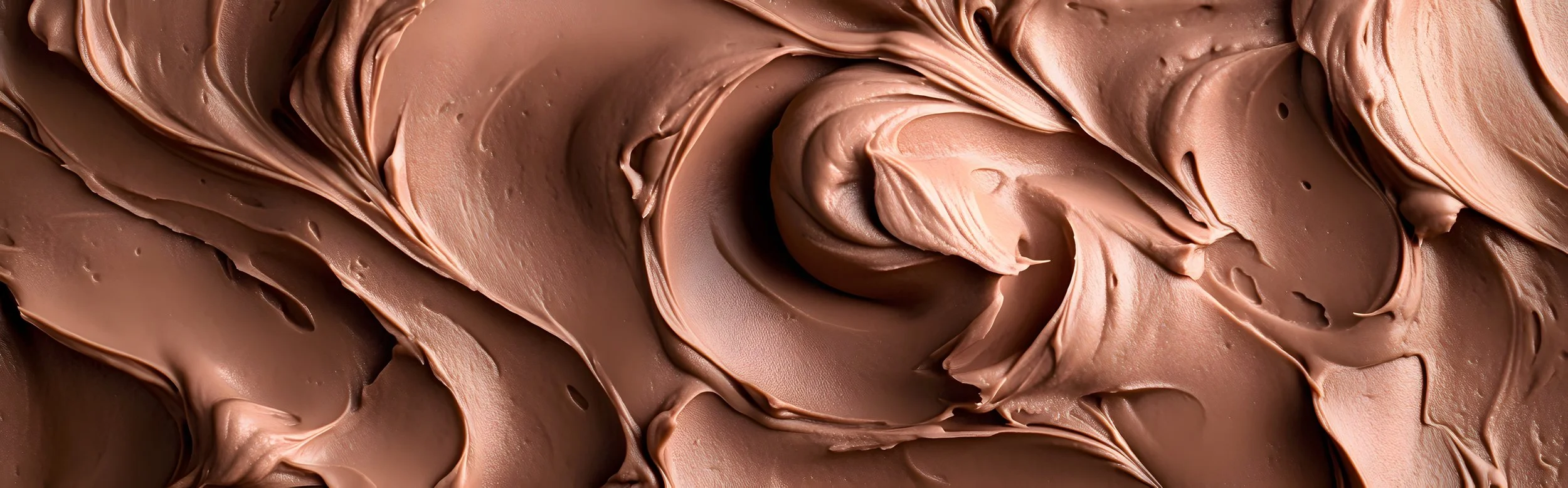Close-up of creamy, swirled chocolate spread or frosting.