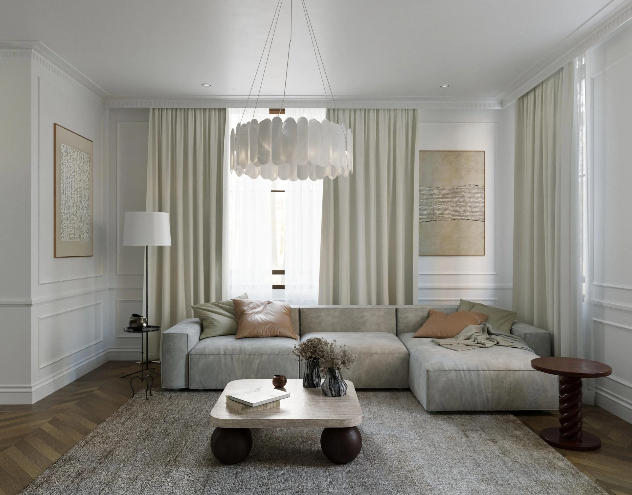 Living room with white walls, large windows with sheer curtains, a modern chandelier, beige sectional sofa with pillows, a wooden coffee table with books and vases, a round side table, and abstract wall art.