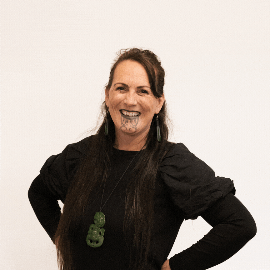 Nicky Birch, Pou Kōrero, stands in front of a white background. She changes from smiling, to looking proud, to a heartfelt laugh.