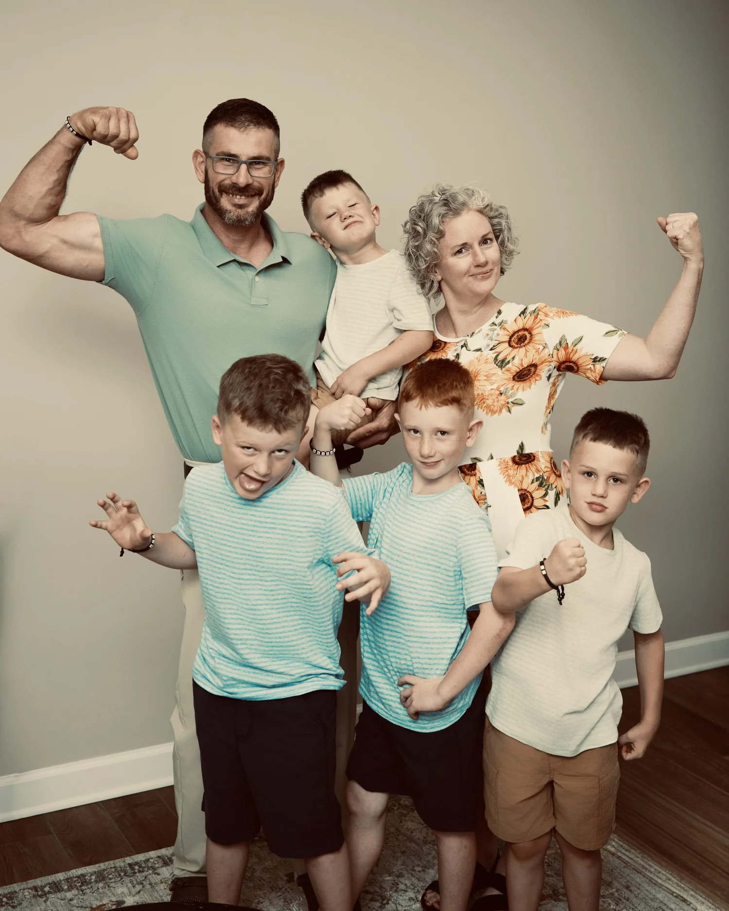 Von and Kacey Carstedt with their children, smiling and flexing their arms