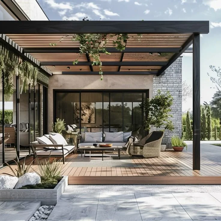 Modern backyard patio with outdoor furniture, plants, and a wooden pergola.