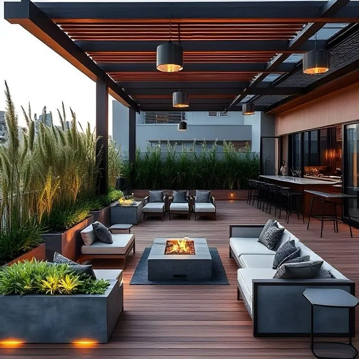 Modern rooftop patio with seating, fire pit, bar area, and greenery