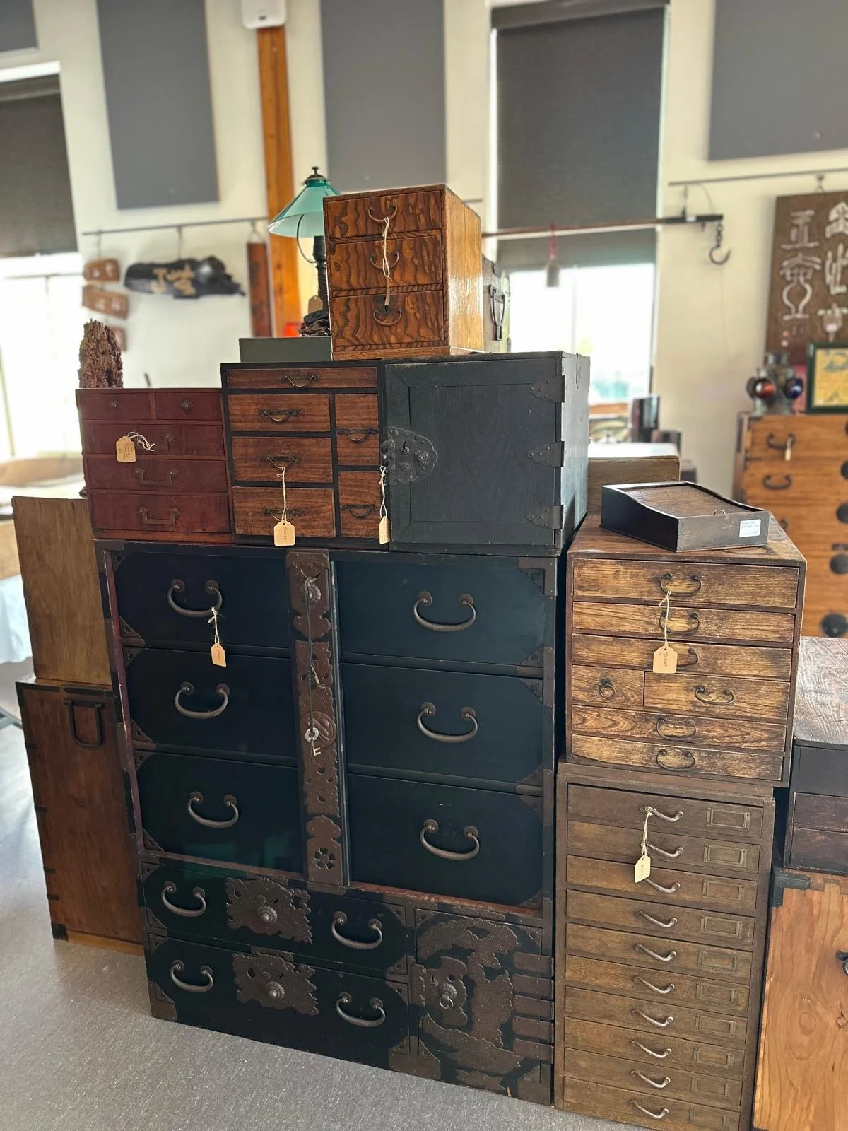 Grouping of Japanese antique tansu furniture featuring iron fittings, drawers, and storage compartments, displayed to highlight construction and age.