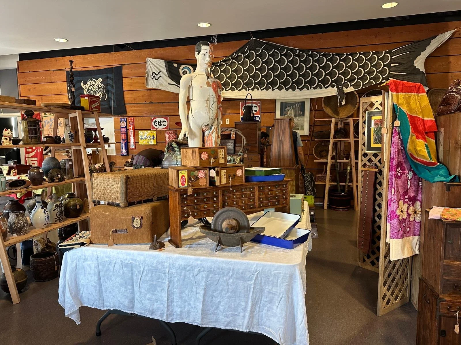 Interior view of a Japanese antiques pop-up featuring hand tools, furniture, ceramics, textiles, and architectural elements, curated and displayed in Port Townsend, Washington.