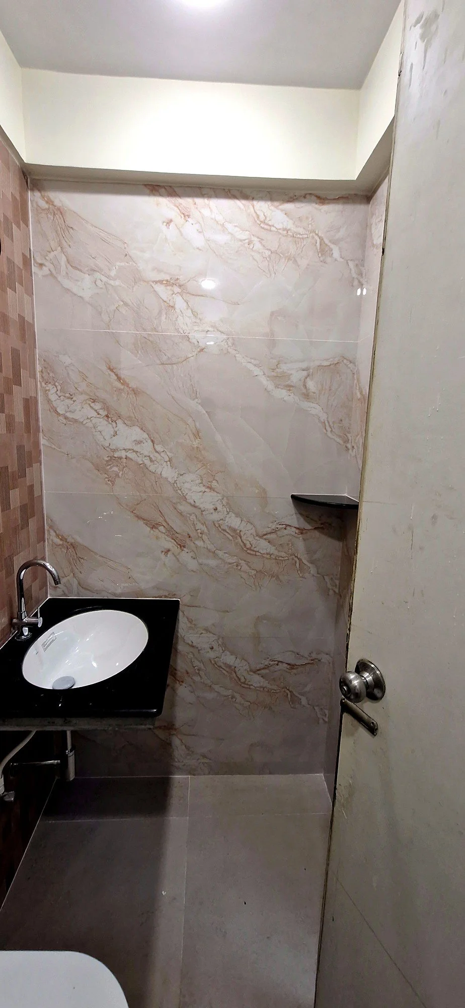Bathroom vanity with marble-finish walls at Lake Pleasant Powai 2BHK