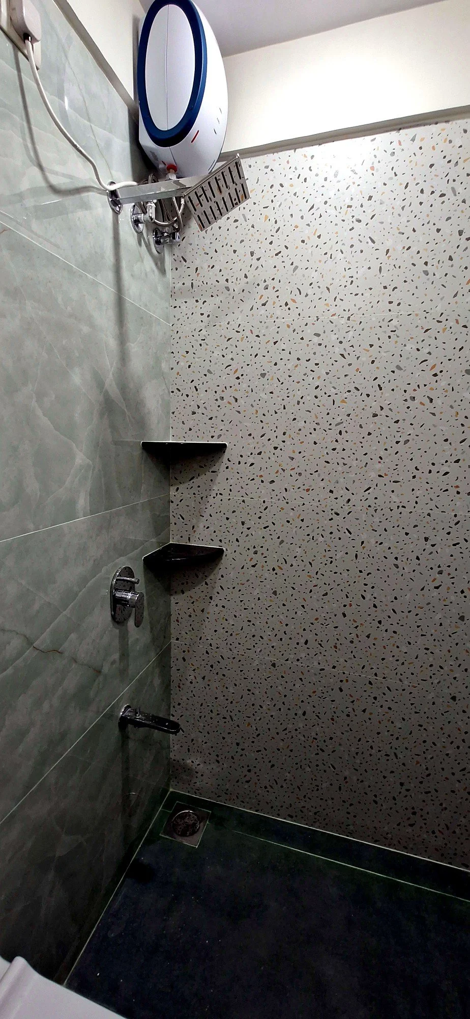 Shower area with textured terrazzo tile finish at Lake Pleasant Powai 2BHK