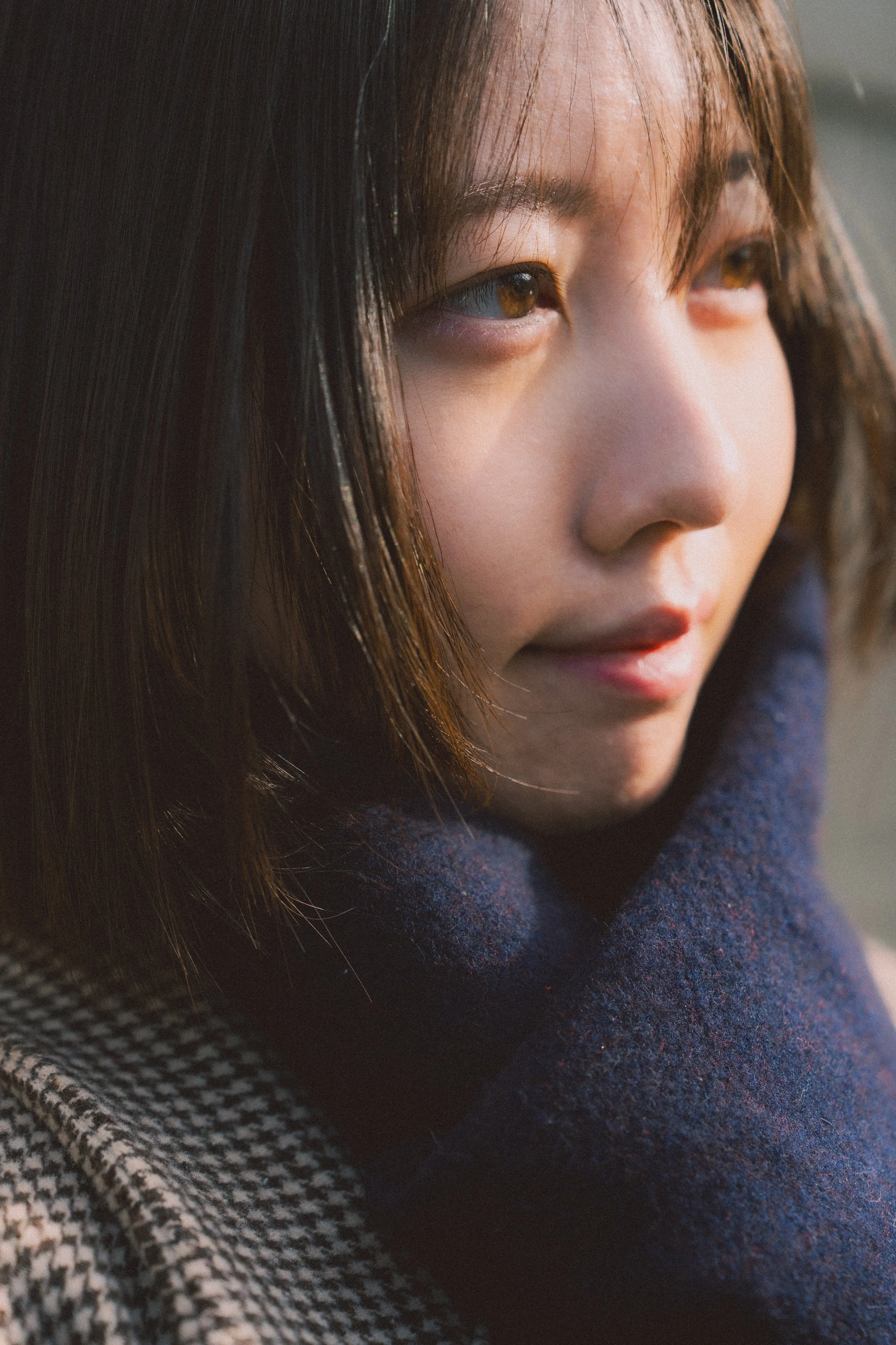 女性の顔のアップ写真、自然光の中で側面から撮影されたもの。