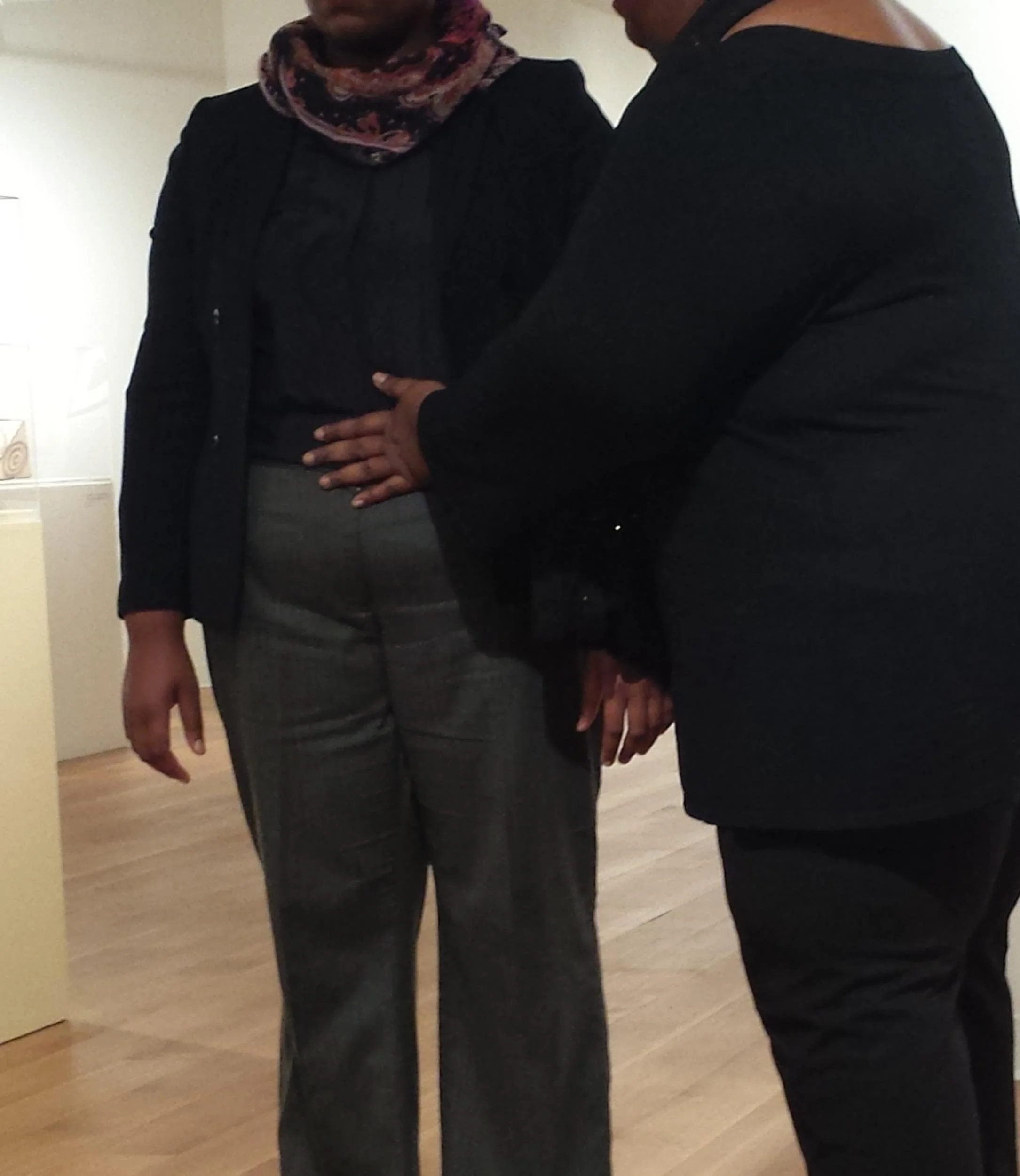 Two people standing together, one has their hand on the other's chest.
