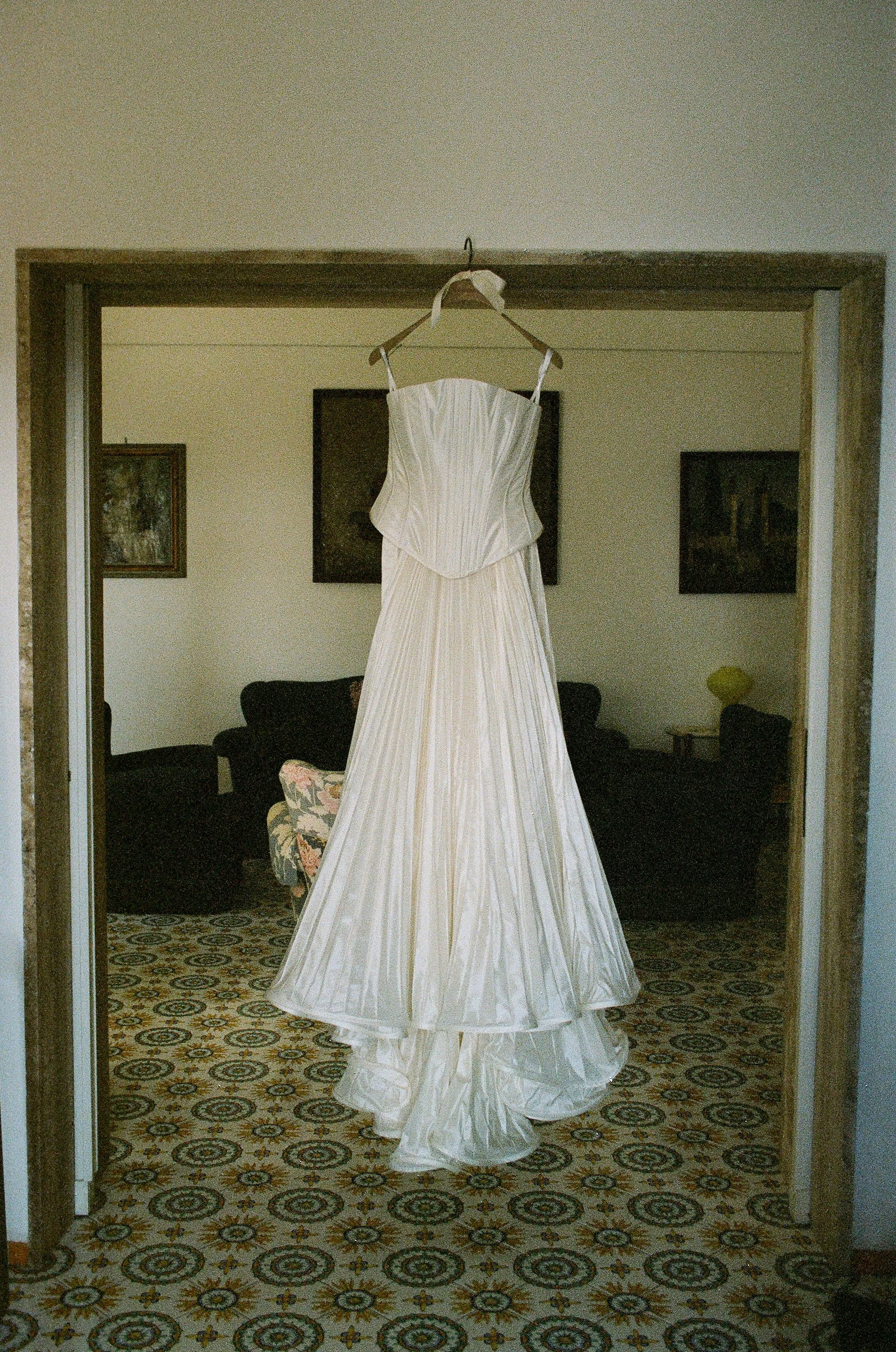 Abito da sposa bianco appeso in una stanza.
