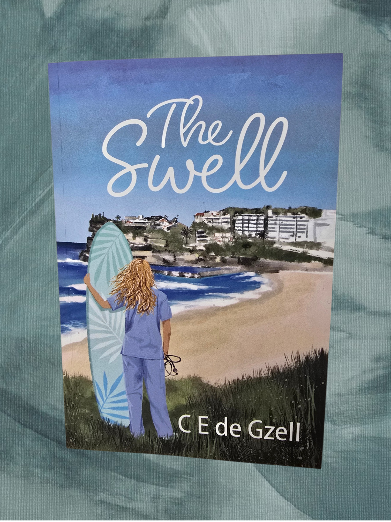 Book cover titled 'The Swell' by C. E de Gzell, depicting a woman with long curly hair holding a surfboard on a beach with buildings in the background.