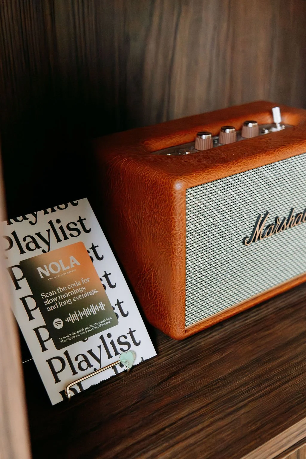 Een speaker met Marshall-logo naast een playlistkaart van Spotify met QR-code