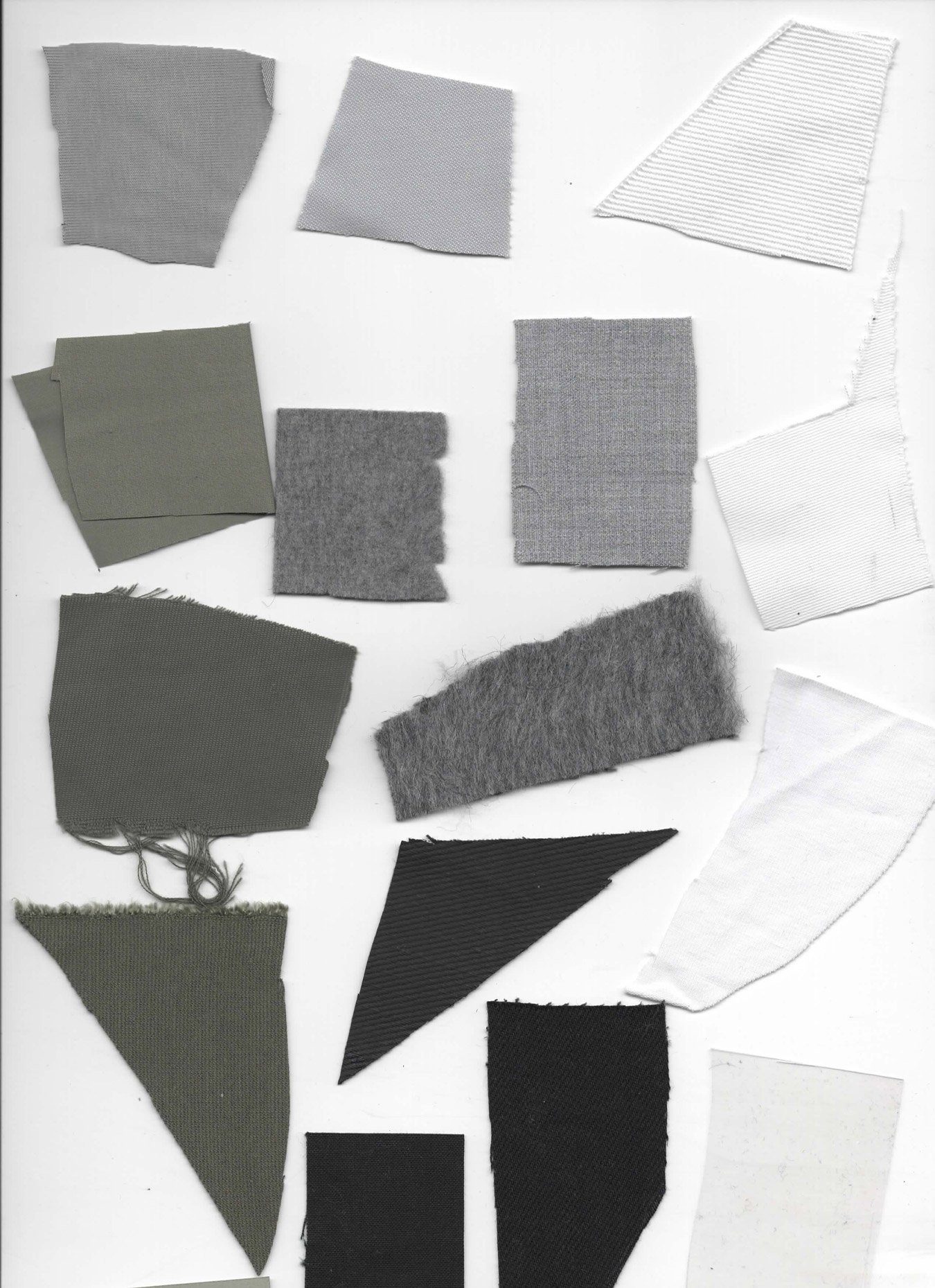 Verschiedene Stoffstücke in Weiß, Grau-, Oliv- und Schwarztönen auf weißem Hintergrund.