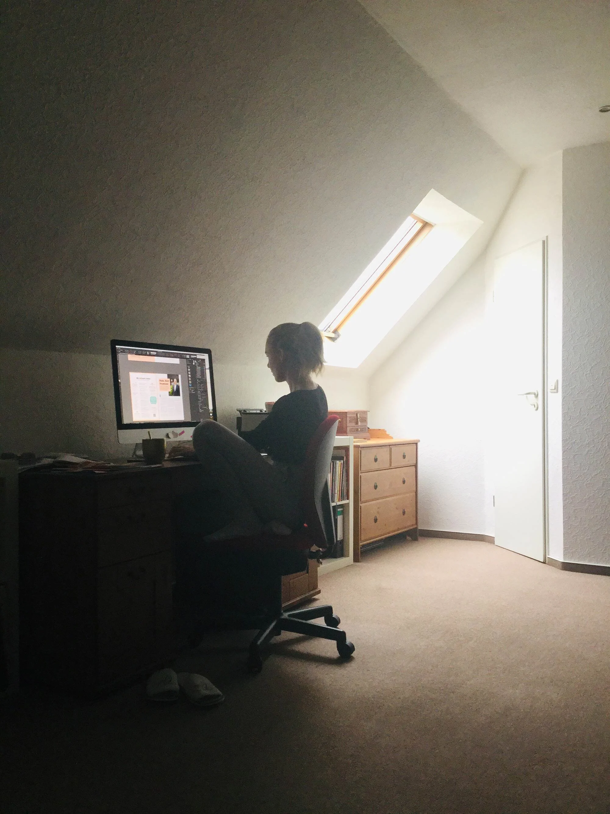 Superidee Mitarbeiterin Lisa sitzt im Home Office in einem Dachgeschosszimmer vor ihrem Computer.