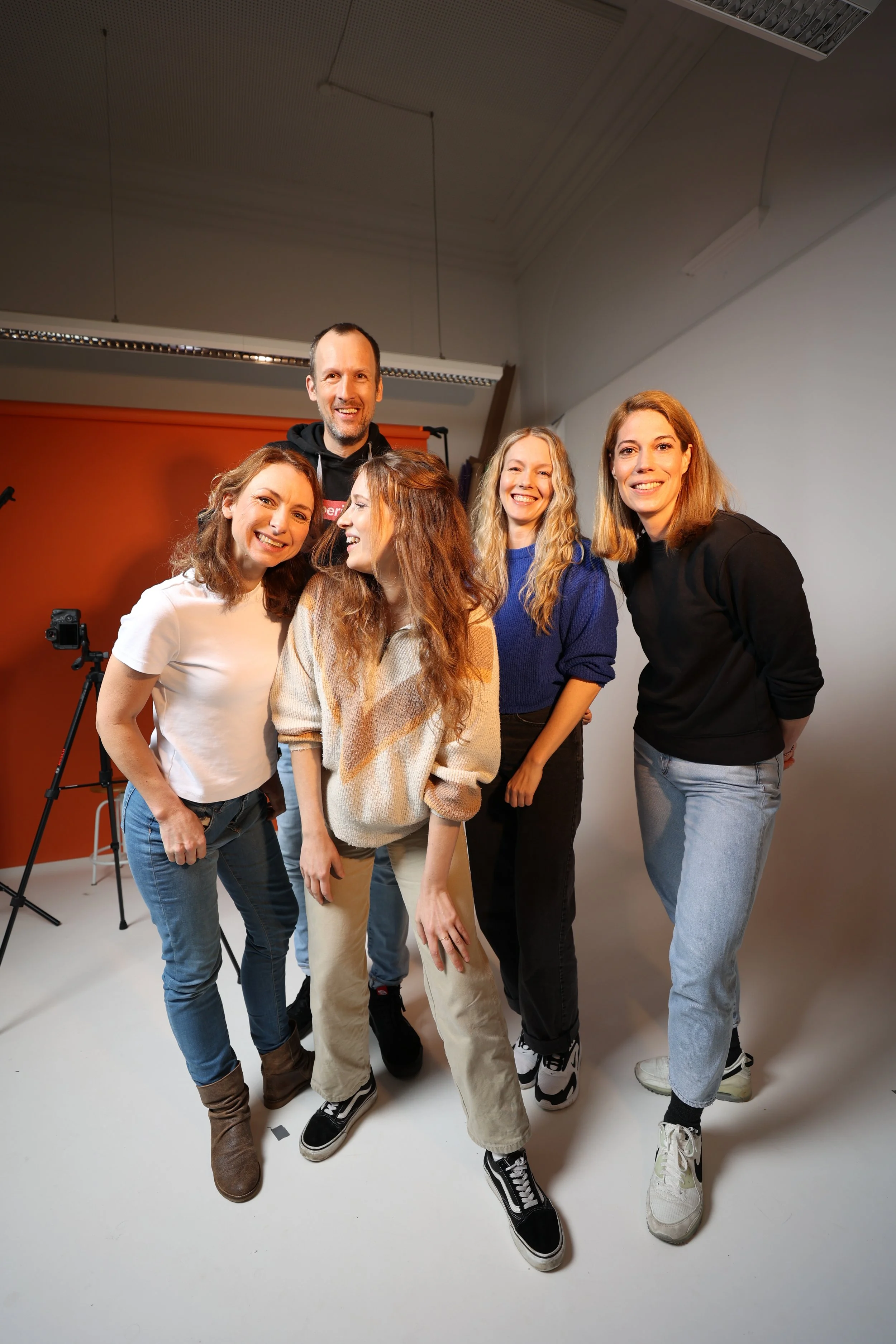 Eine Gruppe mit vier Frauen und einem Mann lächelt in die Kamera. Das ist das Team von Superidee Werbeagentur Oldenburg.