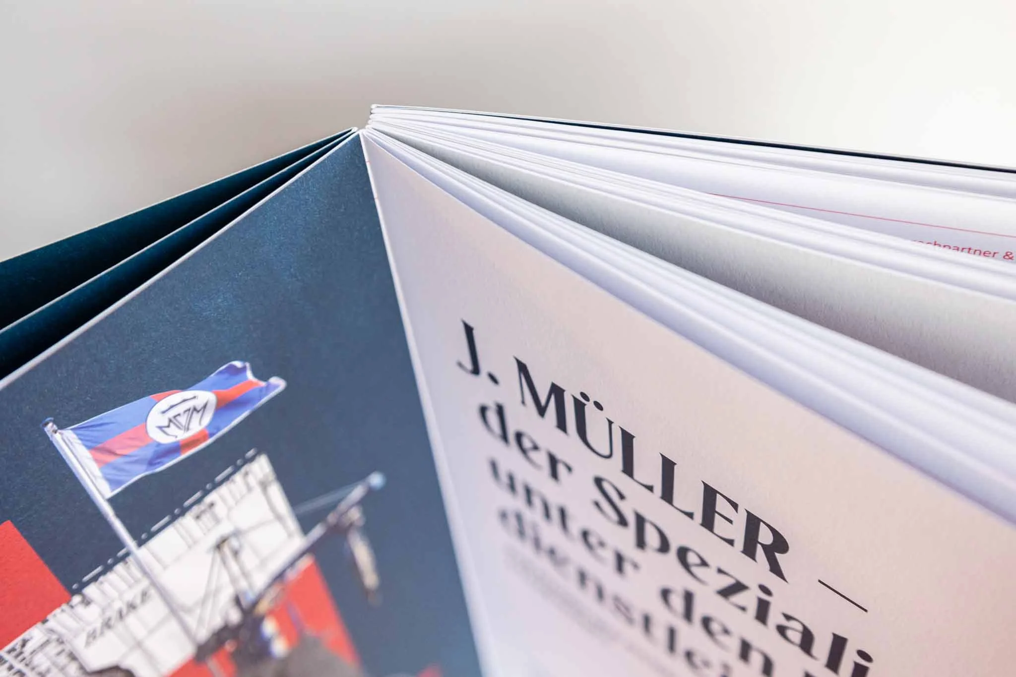 Blick auf die umgekrempelte Seite eines Buches oder Magazins, das einige Wörter und ein Bild eines Segelflugzeugs und eines Logos zeigt.